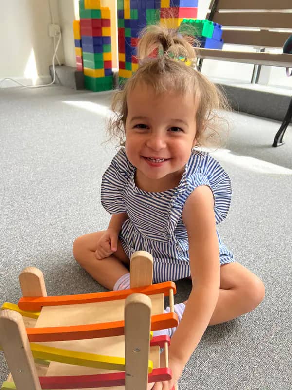 Toddler smiling on the play floor at The Little Play Co.
