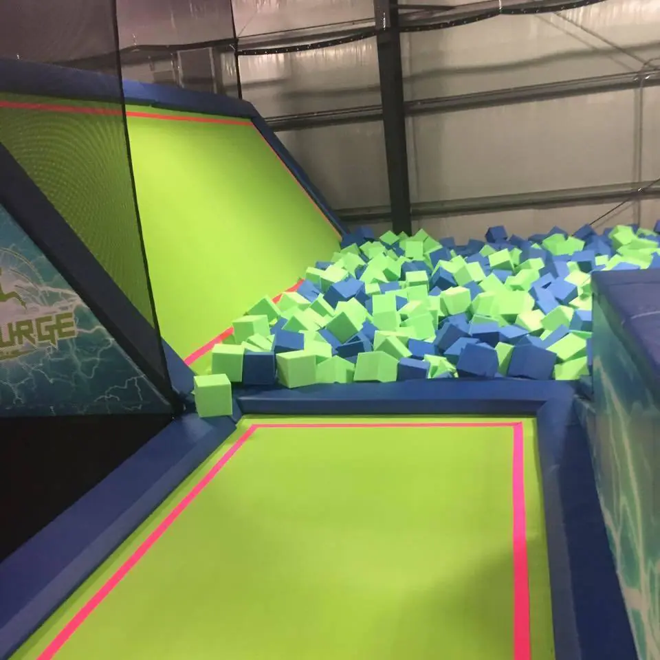 Trampoline lane leading toward a foam pit at UpSurge Trampoline Park.