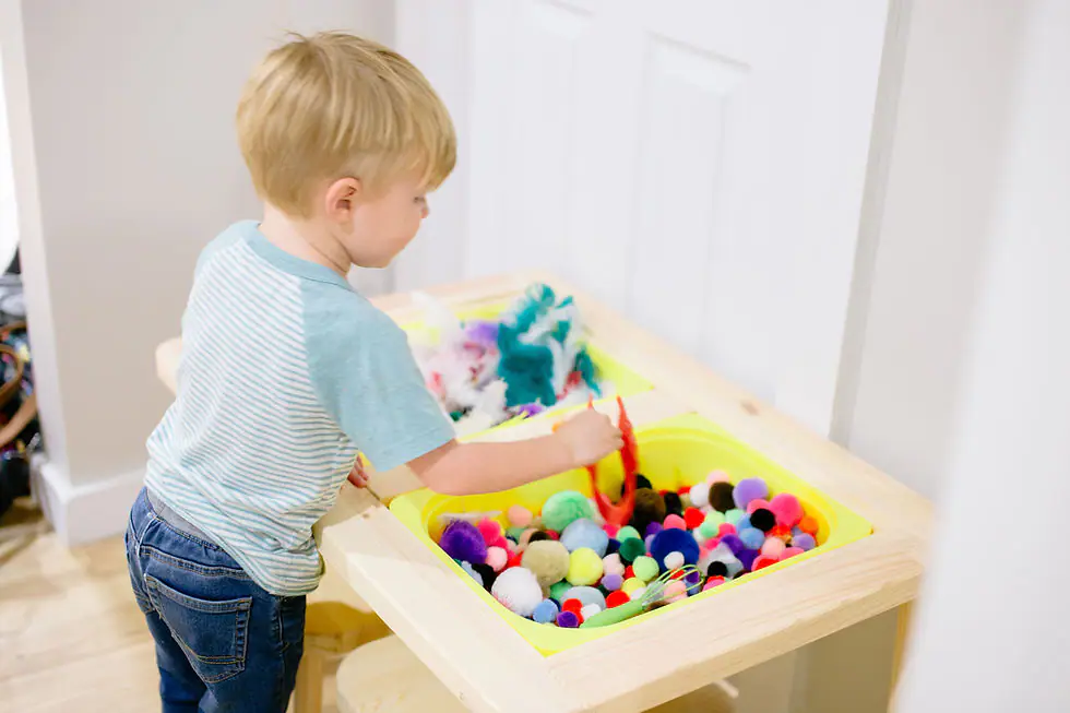 Child using a sensory bin at The Play Hut.