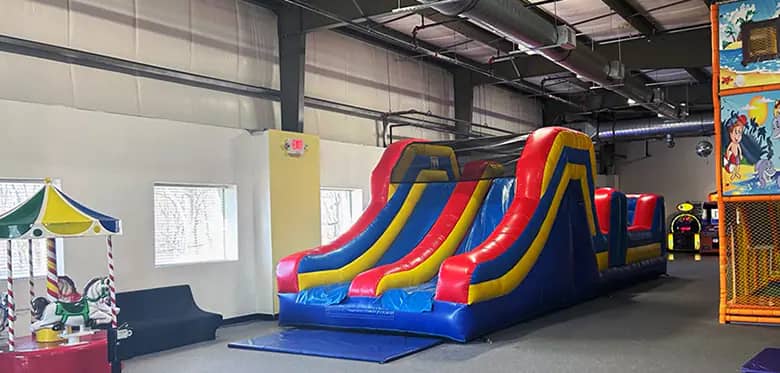 Large inflatable slide and open play floor at BB Kidz Klub.