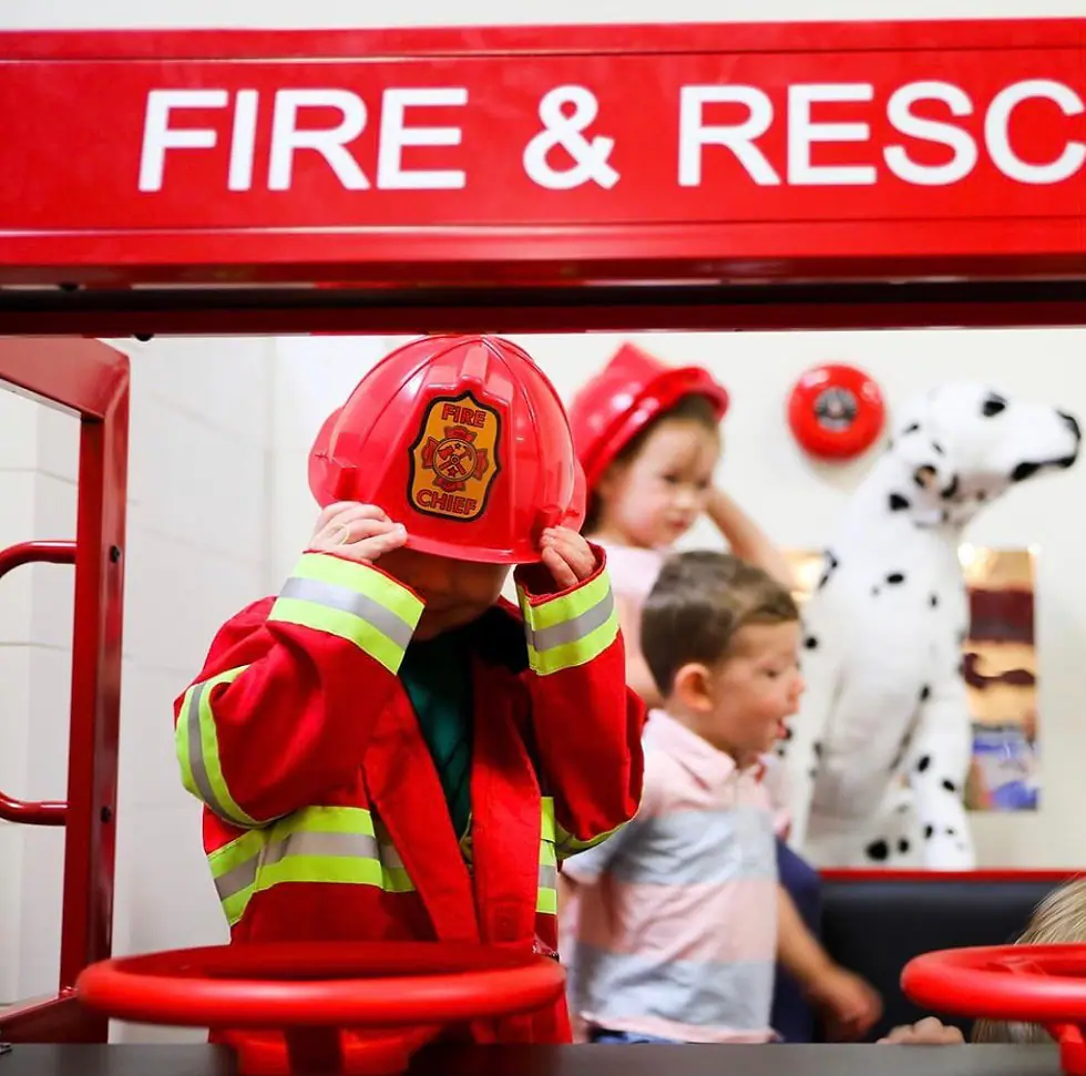 Children playing in a pretend fire station area at Kid & Caboodle Play.