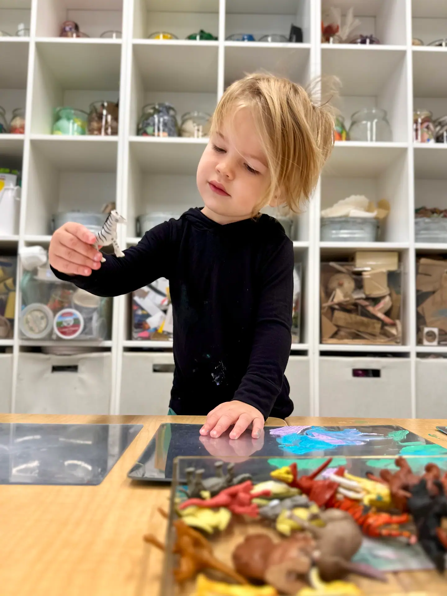 Child using art materials in the art studio at State of Play