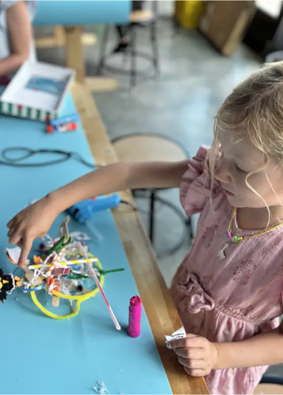 Child making a craft at a work table inside Jackson Hole Children's Museum.