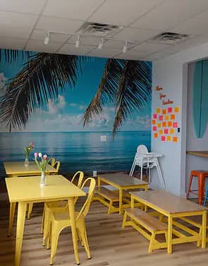 Colorful café seating area with ocean mural at Happy Days Play Cafe