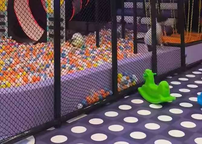 Large fenced ball pit and tunnel-slide play area at Kids Jungle Playground