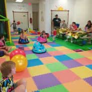 Open floor play and seating area at Wild Wonders Playspace.