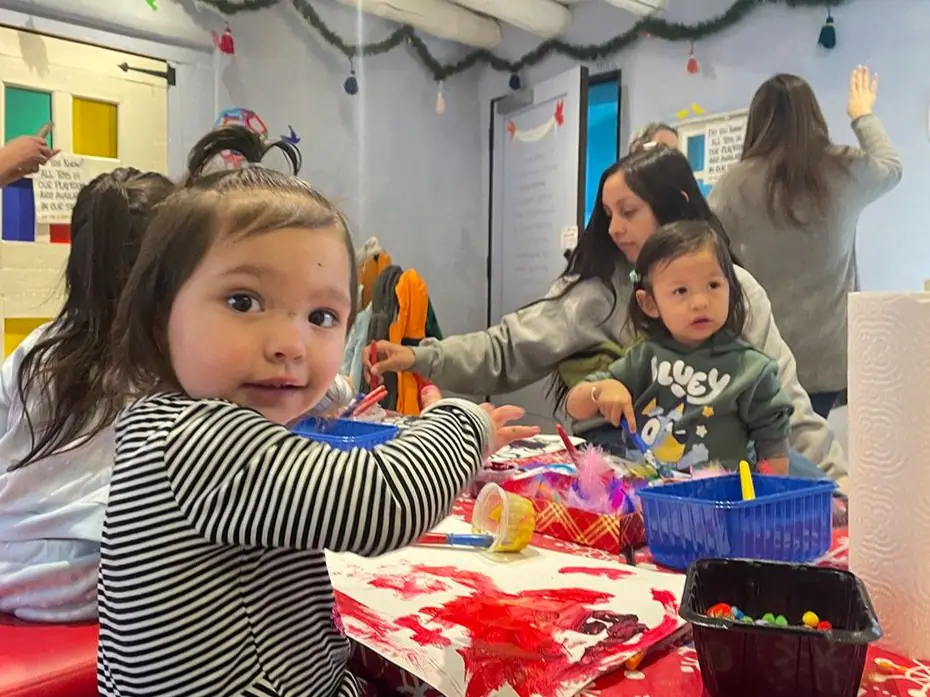 Children and caregivers doing crafts together inside Twirl's indoor playroom in Taos.