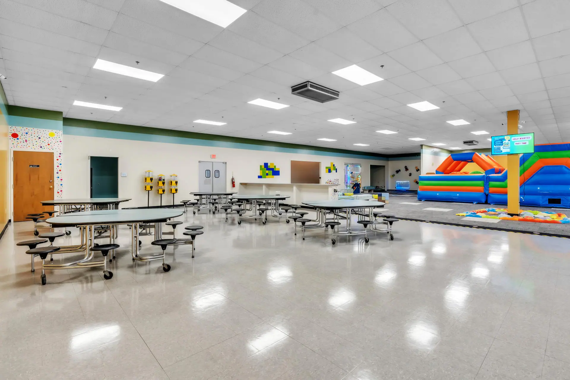 Party and seating area beside the larger play floor at Seek & Find Indoor Playscape.
