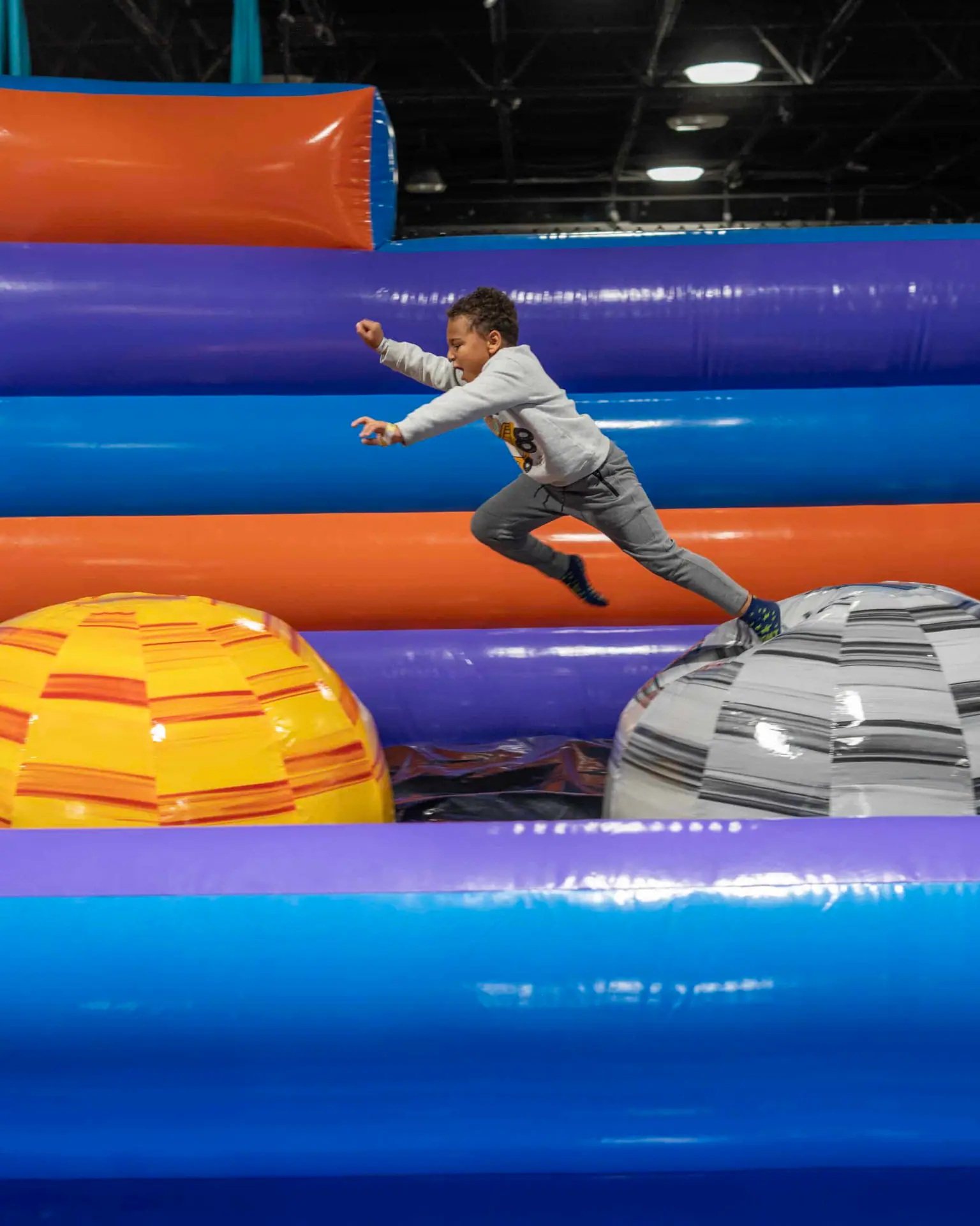 Child running across inflatable play elements at Flight Adventure Park.
