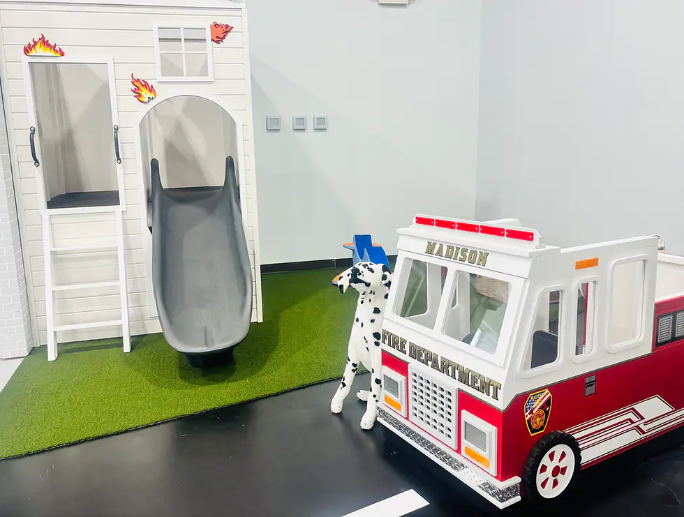 A child-size fire station play structure inside Imagine That.