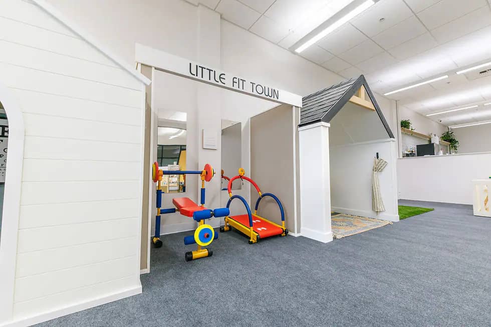 Pretend-play storefront and child-sized fitness toys at Playtown Cafe