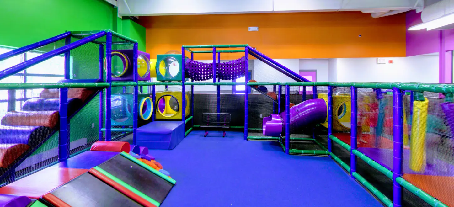 Multi-level indoor play structure and colorful play areas at Sapora Playworld in Loves Park.