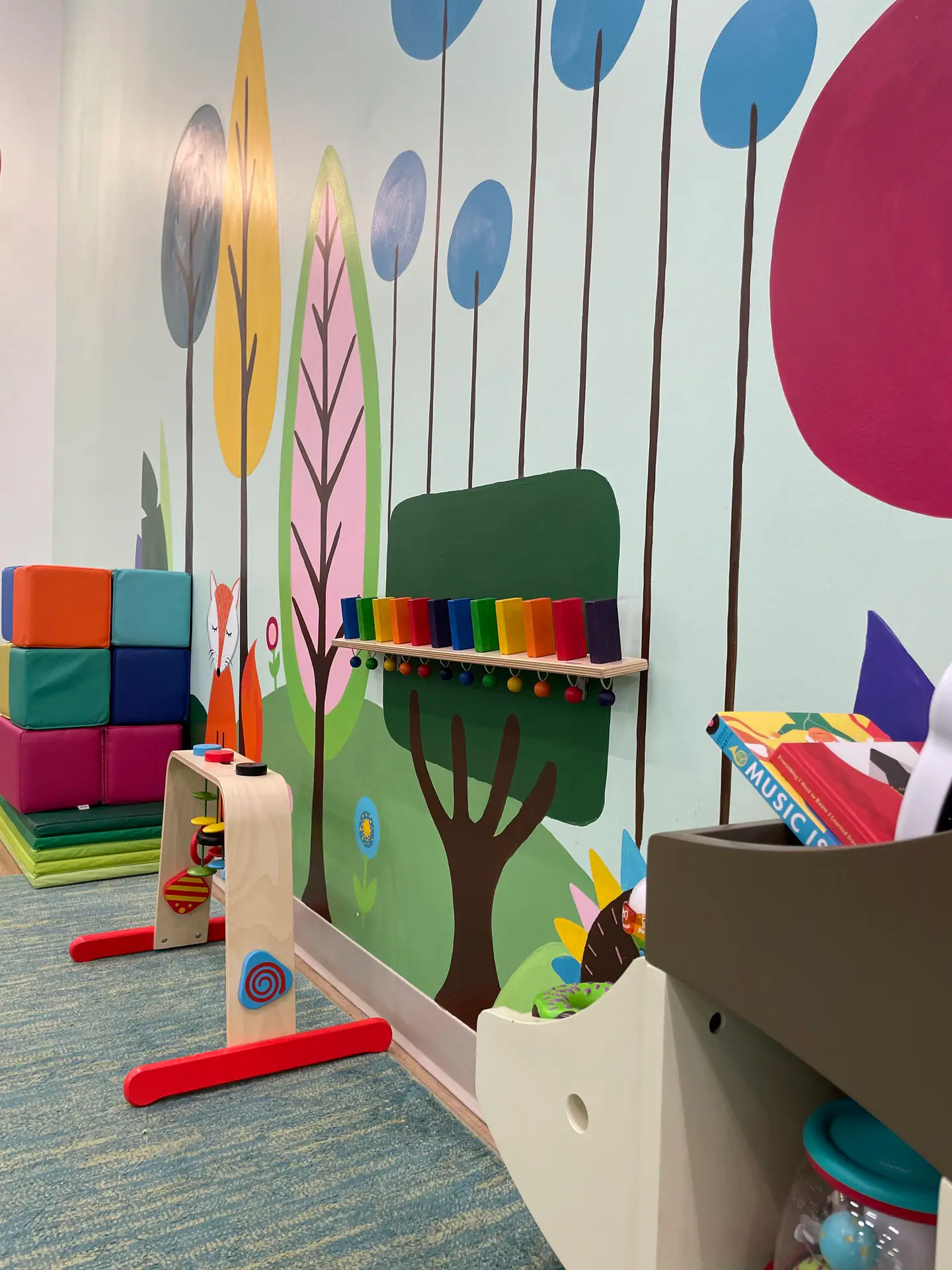 Colorful sensory and toy area with mural wall and toddler-scale activities at Where the Wild Things Play.
