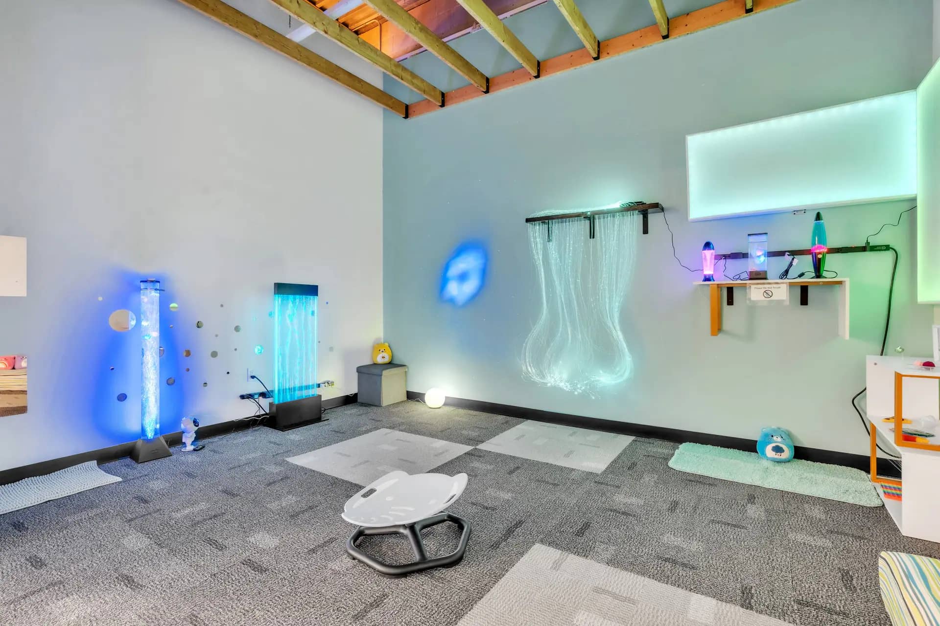 Sensory room with bubble tubes and calming lights at Seek & Find Indoor Playscape.