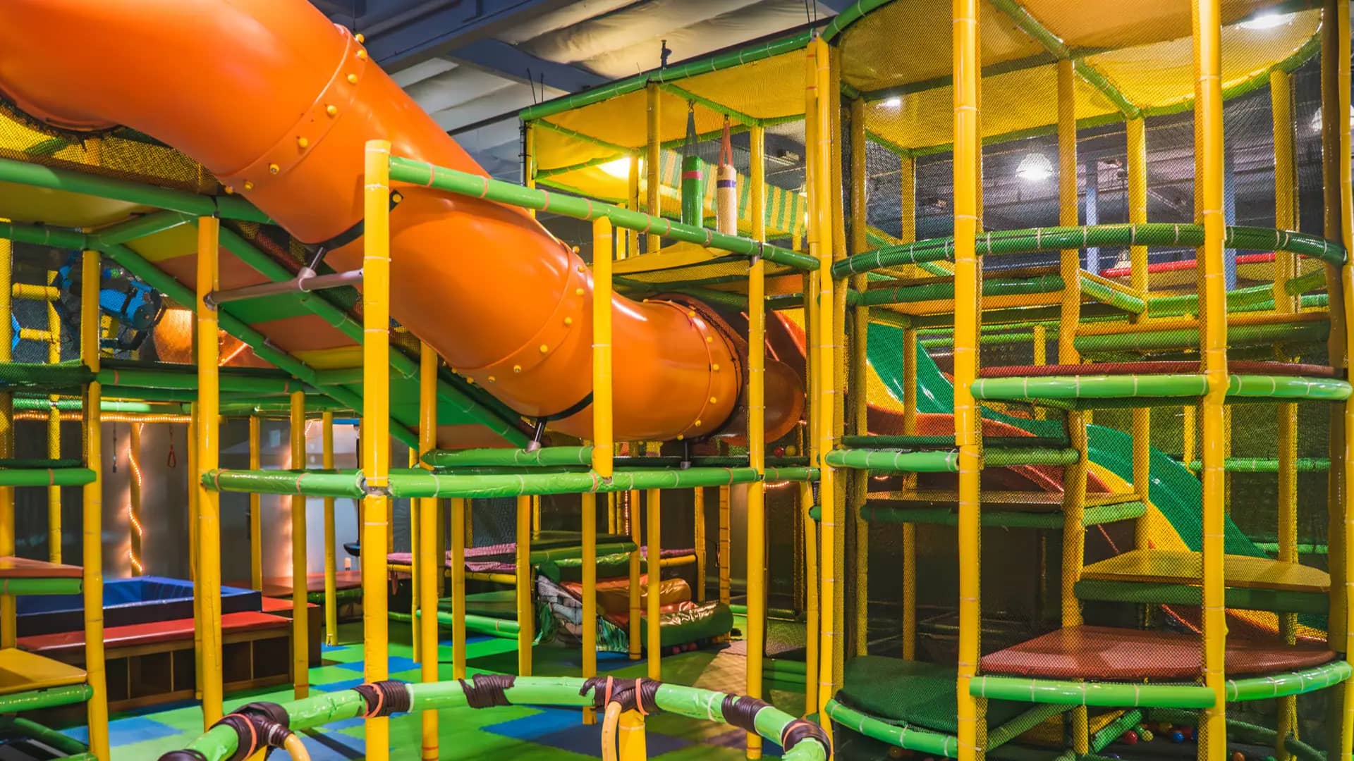 Large orange tube slide and climbing structure at House of Play.