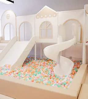 Play House Chester indoor play structure with twin slides leading into a pastel ball pit.