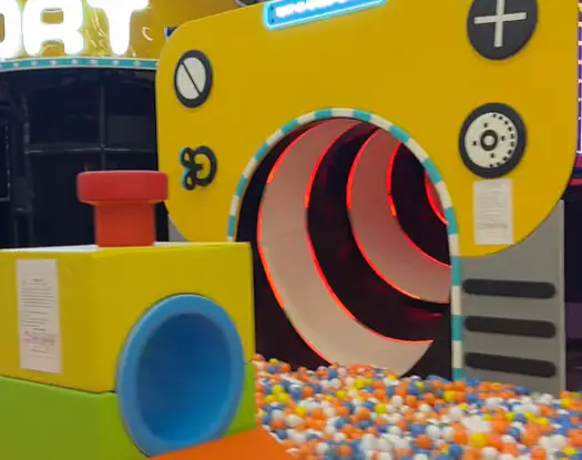 Yellow tunnel-style play entrance with a ball pit landing at Kids Jungle Playground