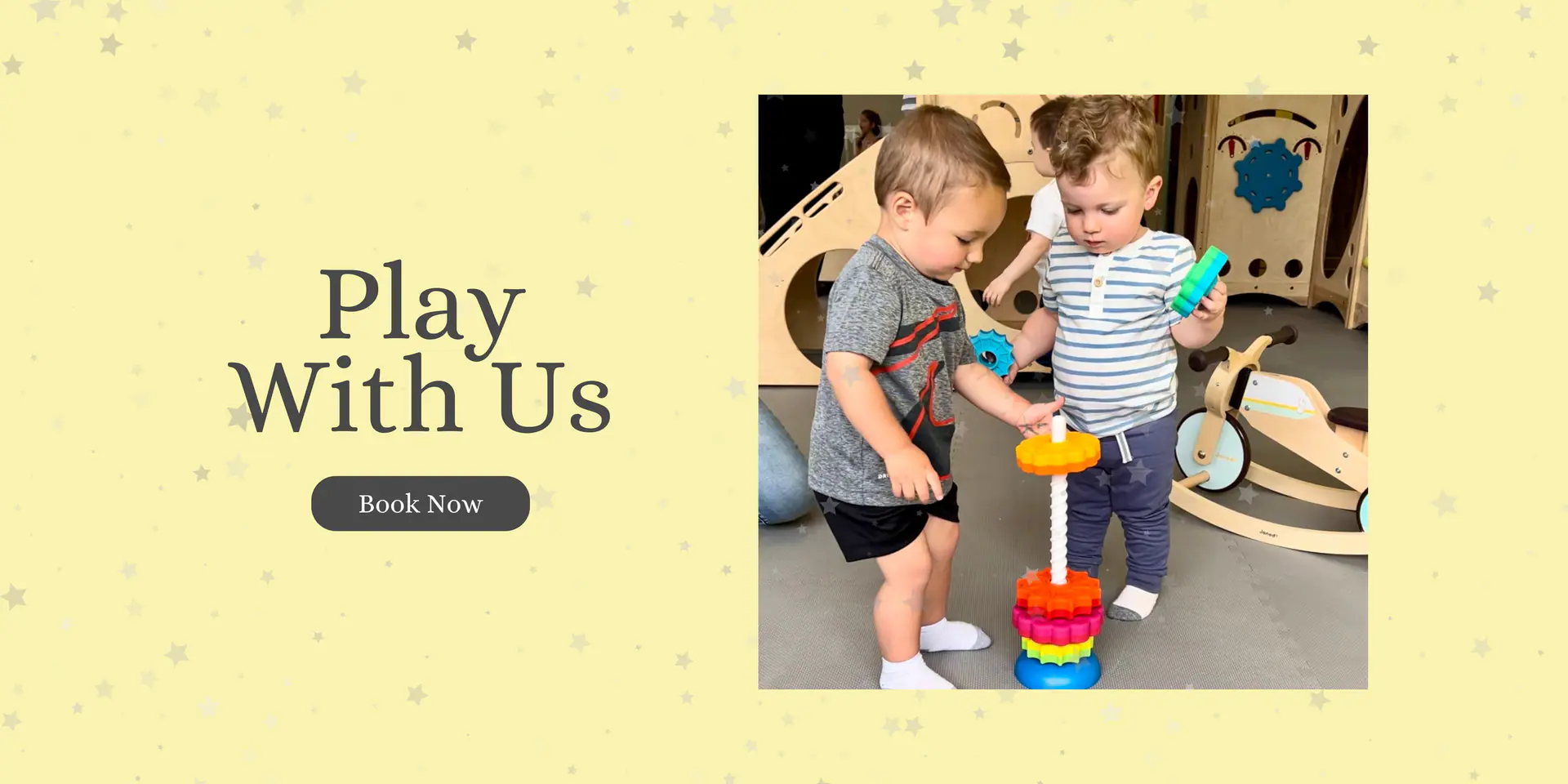 Two toddlers playing with large building toys inside La La Land's open-play space in Babylon Village.