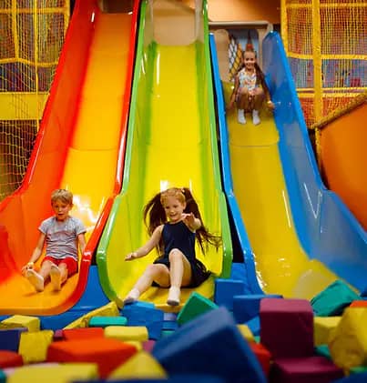 Kids sliding on brightly colored slides at Wonderworld Playzone.