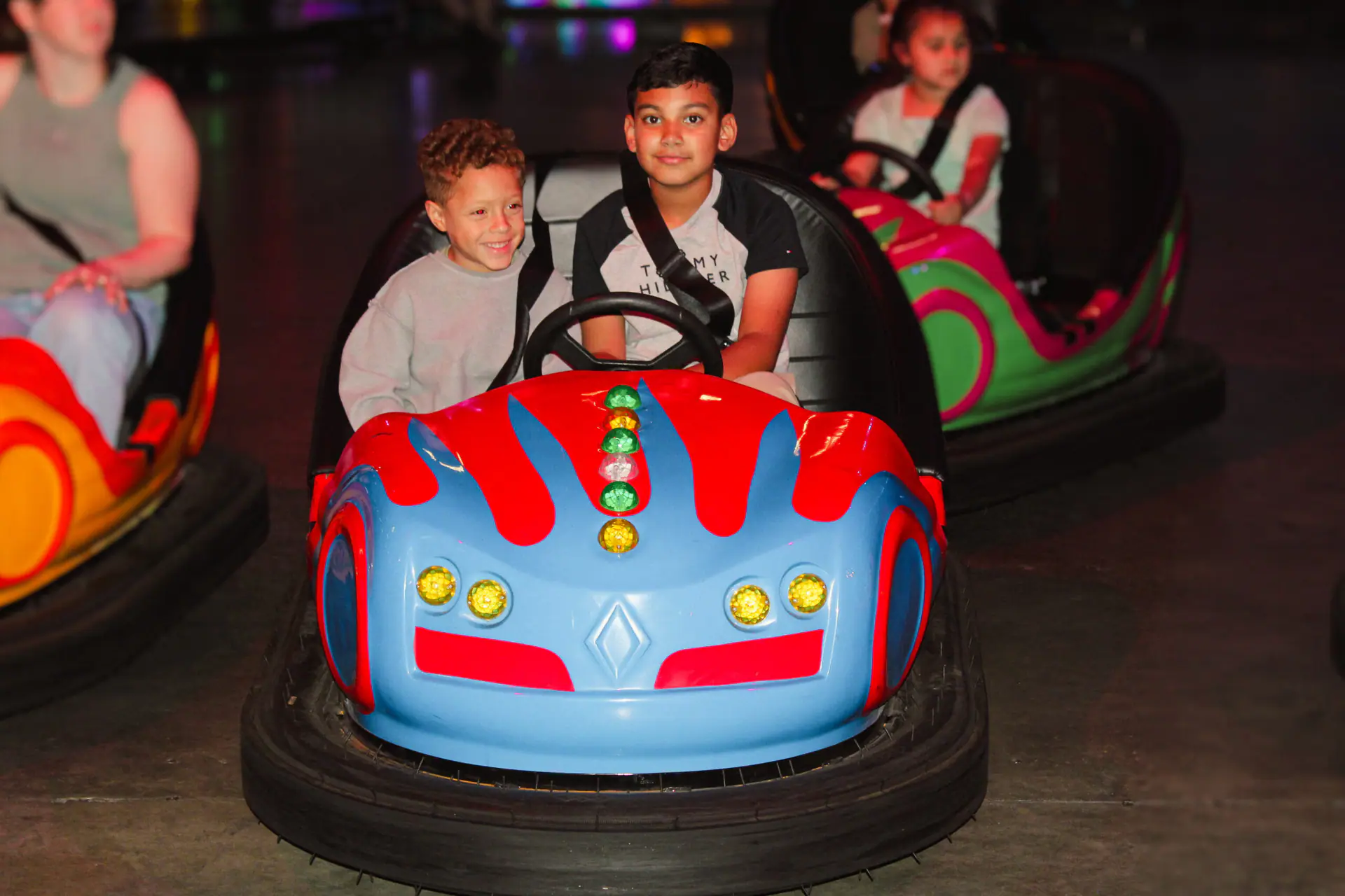 Children riding bumper cars inside Planet Obstacle.