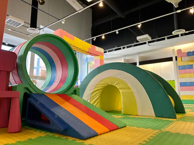 Rainbow soft-play climbers and tunnel inside Sunshine Play Cafe in Richmond.