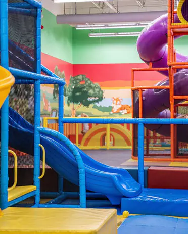 Indoor climbing structure with soft-play slides at Kidzville Catonsville.